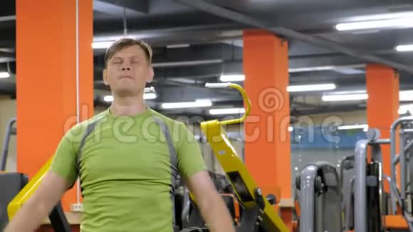 一个男人在后三角洲做运动哑铃坐在健身室里直握手视频的预览图