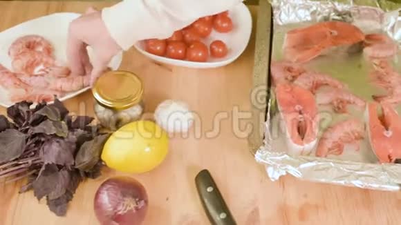 在烤制海鲜的烤盘上铺上女性手的特写视频的预览图
