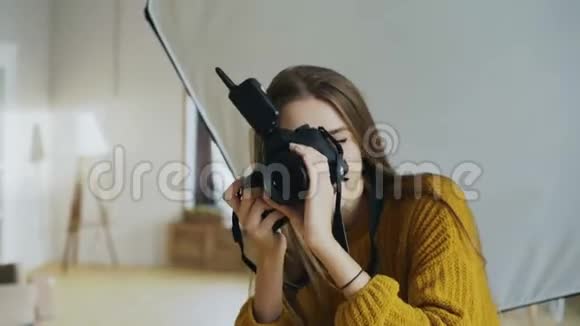 年轻女性摄影师在照相馆工作用数码相机拍摄男性模特的照片视频的预览图