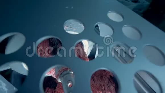 碎肉从一台有孔的金属板从顶部的切肉机上掉落视频的预览图