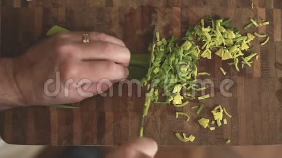 男人把叶子的韭菜切成小片在视频的顶部视频的预览图