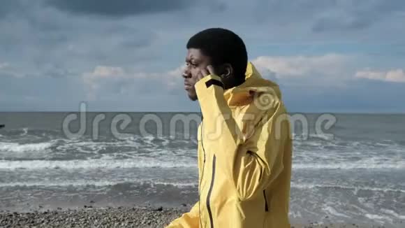 非洲男人在海岸边听音乐跳舞视频的预览图