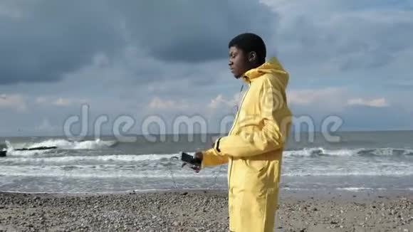 非洲男人在海岸边听音乐跳舞视频的预览图
