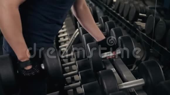 强壮的男人的手拿着一个沉重的哑铃在健身房近距离宏观室内运动的家伙视频的预览图