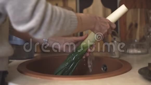 女人在冷水流下洗韭菜视频视频的预览图