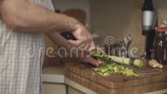 男人把韭菜切成视频侧面的小块视频的预览图