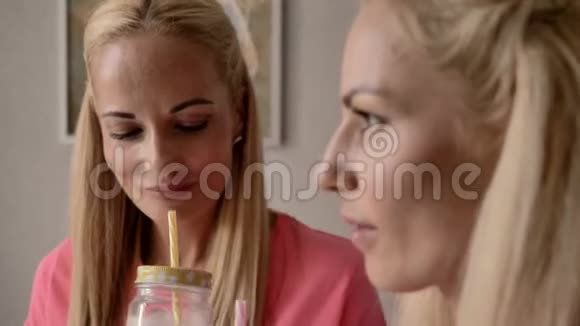 金发碧眼的双胞胎姐妹喝一杯带管子的奶昔视频的预览图