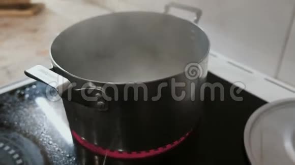 特写的米面落入灶台上的一锅热水侧视视频的预览图