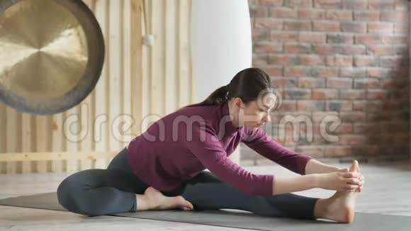年轻迷人的运动女性在健身房练习瑜伽视频的预览图