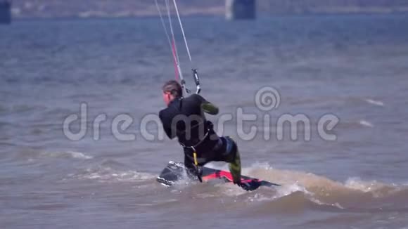 顺流动浪一个雄性的风筝板沿着一条大河的波浪美丽地移动溅起的水花视频的预览图