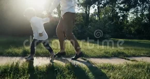 父亲带着儿子在公园慢跑慢动作家庭幸福4k红色史诗视频的预览图