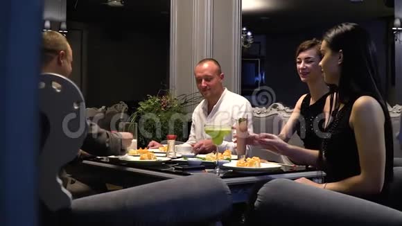 朋友们在餐厅休息吃寿司喝鸡尾酒喝咖啡慢动作视频的预览图