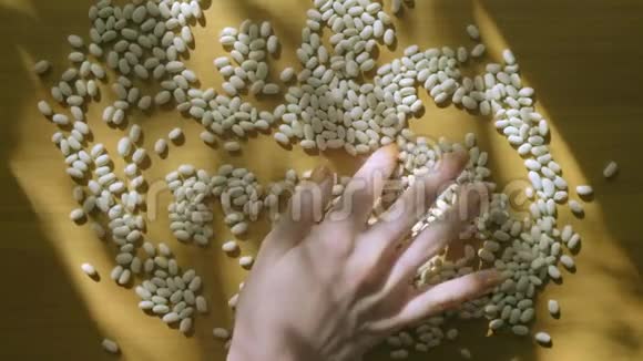 女人的手在自然光线下玩卡尼利尼豆视频的预览图