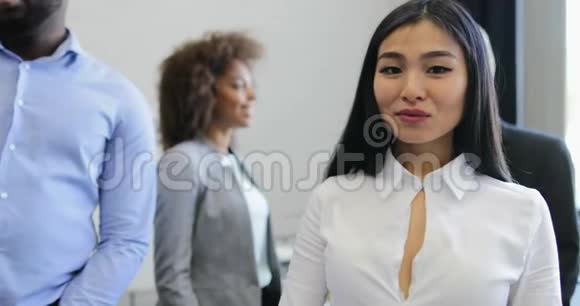 美丽的亚洲女商人走在现代创意办公室与同事会面交谈商务人士小组视频的预览图