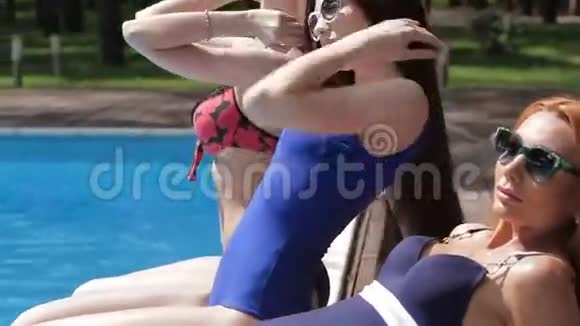 三个女人在游泳池附近放松视频的预览图