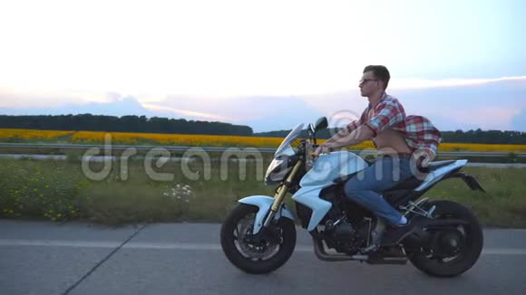 骑着现代摩托车的年轻人穿着衬衫戴眼镜驾驶摩托车的帅气摩托车视频的预览图