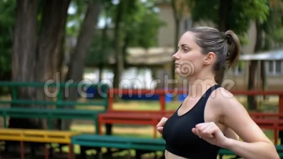 运动女孩在公园的运动场上进行热身运动视频的预览图
