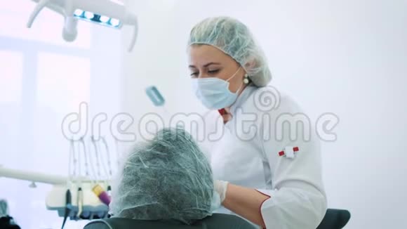 办公室的女牙医一位女医生牙医正在研究一位男性病人的下巴和牙齿看着摄像机视频的预览图