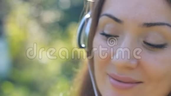 戴着耳机的年轻女人听音乐肖像特写视频的预览图