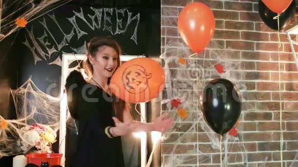 万圣节庆典小女巫拿着南瓜玩气球穿着恐怖服装的少女视频的预览图