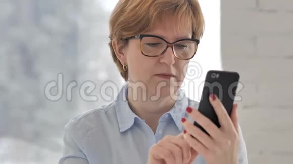 老女人在使用智能手机时面对损失视频的预览图