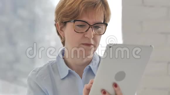 使用平板电脑浏览互联网的老妇人视频的预览图