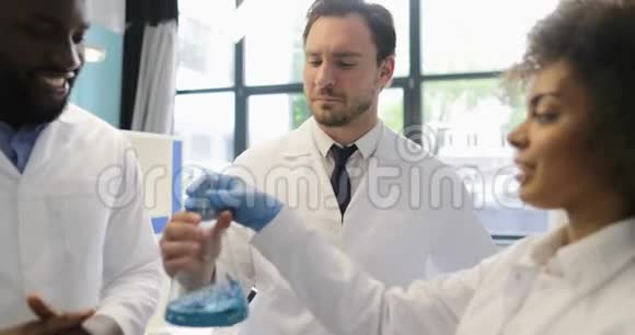 不同的科学家小组分析瓶子里液体的气味在实验室里做实验混合种族小组视频的预览图