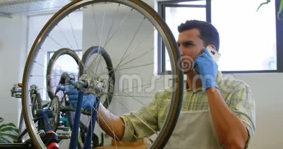 修理自行车的人在用手机说话视频的预览图