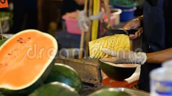 卖家正在用刀子清洗柜台后面的菠萝亚洲街头美食泰国视频的预览图