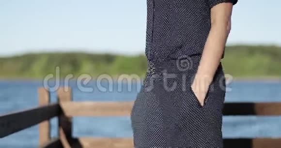 一个女孩正在湖边的一个露台上摆姿势背景是美丽的风景视频的预览图