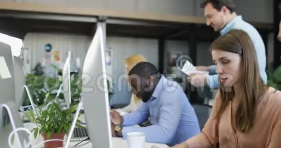 现代的合作空间与一群在电脑上工作的商人忙碌的商人团队混合种族视频的预览图