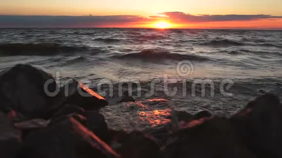 红色的天空覆盖着岩石海岸日落景观视频的预览图