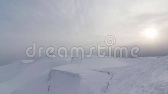 乌云在蓝天上掠过高岩山和雪谷令人惊叹的白色景观视频的预览图