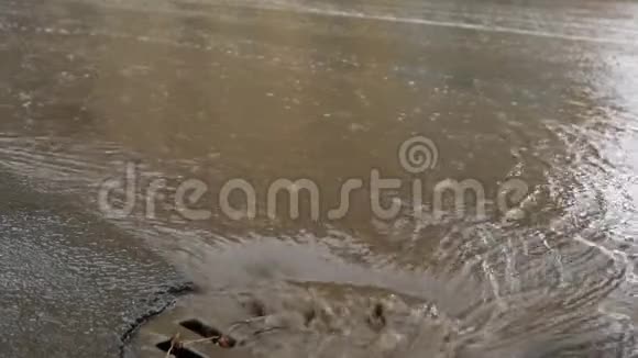 雨水落在道路上流经下水道排水沟汽车在洪水中行驶视频的预览图