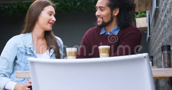 一对情侣在4k的户外咖啡馆相互交流视频的预览图