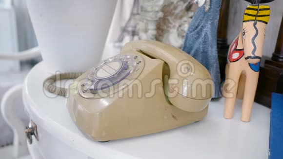 女士手拿起旧的旋转风格电话在桌子上与复古装饰风格和拨打电话号码暖色调复古视频的预览图