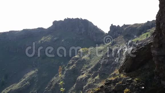 岩石悬崖的斜坡有些部分冒着热气尖顶形成天际线视频的预览图