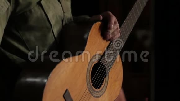 一名身穿军装手持吉他的男子的特写视频的预览图