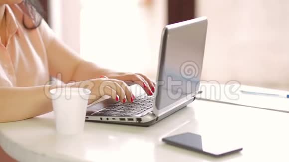 一个年轻女人在笔记本电脑上工作的手慢点视频的预览图