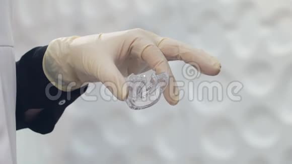 医生的特写戴着手套的手在一个年轻的金发女孩的嘴里放了一个牙齿美白的托盘视频的预览图