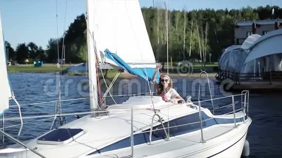 一个时髦的女孩从白色游艇上挥动她的手视频的预览图