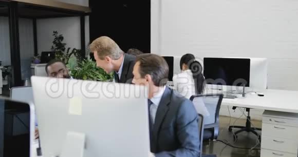 成功的混合种族商务人员团队在现代同事中心工作使用电脑讨论快乐的想法视频的预览图