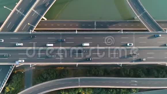 日落时乘坐汽车和卡车的高速公路和立交桥的高空俯视一个现代化的立交桥路口视频的预览图