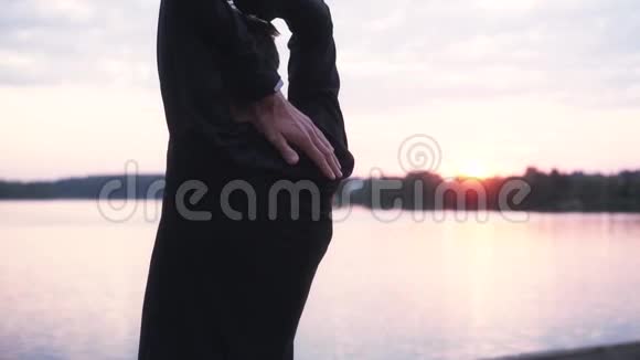慢动作男子伸展手臂靠近日出湖后景男运动员热身美丽静景观视频的预览图