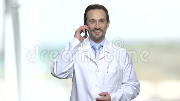 兴奋的穿着白色外套的男人在手机上聊天视频的预览图