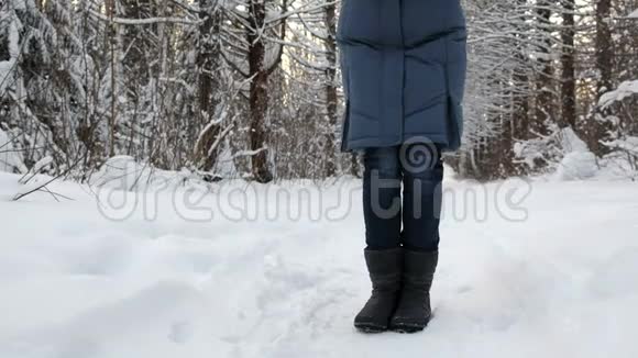 一个穿着靴子的女人冻僵了的腿在雪地里从寒冷中颤抖视频的预览图