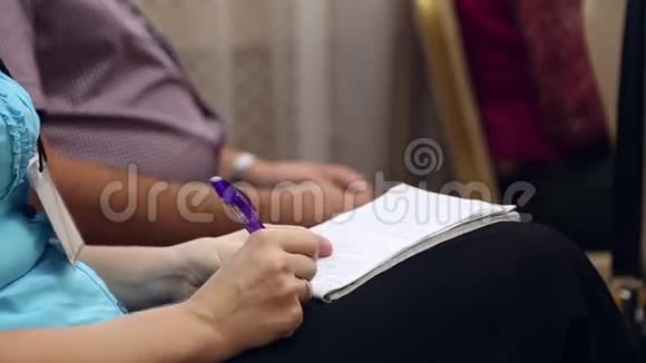 女人在笔记本上写字视频的预览图