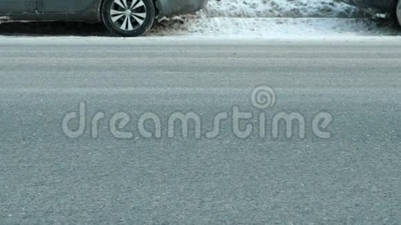 冬季两个方向行驶在道路上的汽车的近距离车轮相机静止视频的预览图