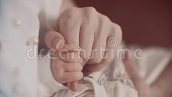 年轻的母亲牵着新生儿的手以缓慢的速度接近视频的预览图