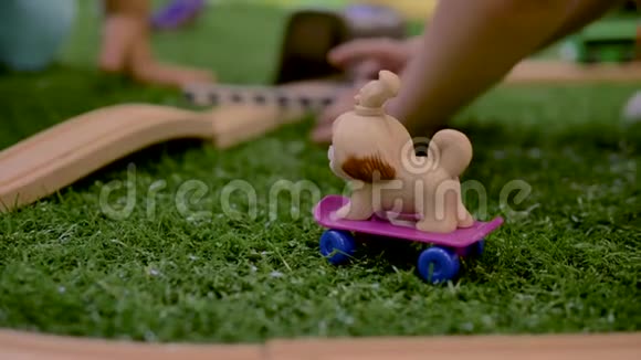 小朋友的手在房间里的紫色滑板上玩塑料玩具狗视频的预览图
